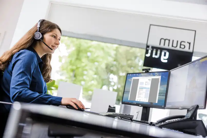Servicemitarbeiterin mit Headset vor dem PC
