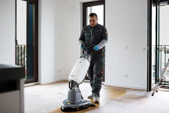 Ein Mitarbeiter mit einer Bodenreinigungsmaschine