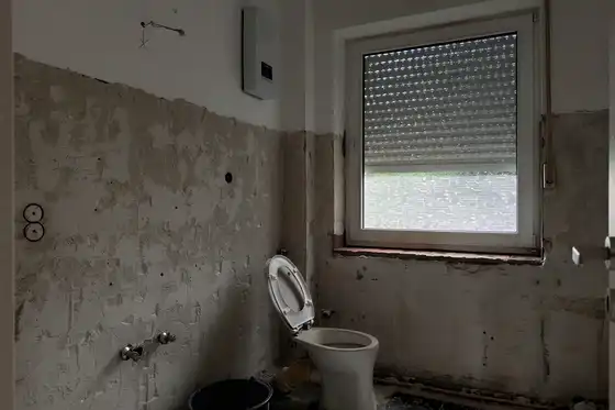 Ansicht eines heruntergekommenen Badezimmers vor der Sanierung als Teaser für Vorher-Nachher-Video